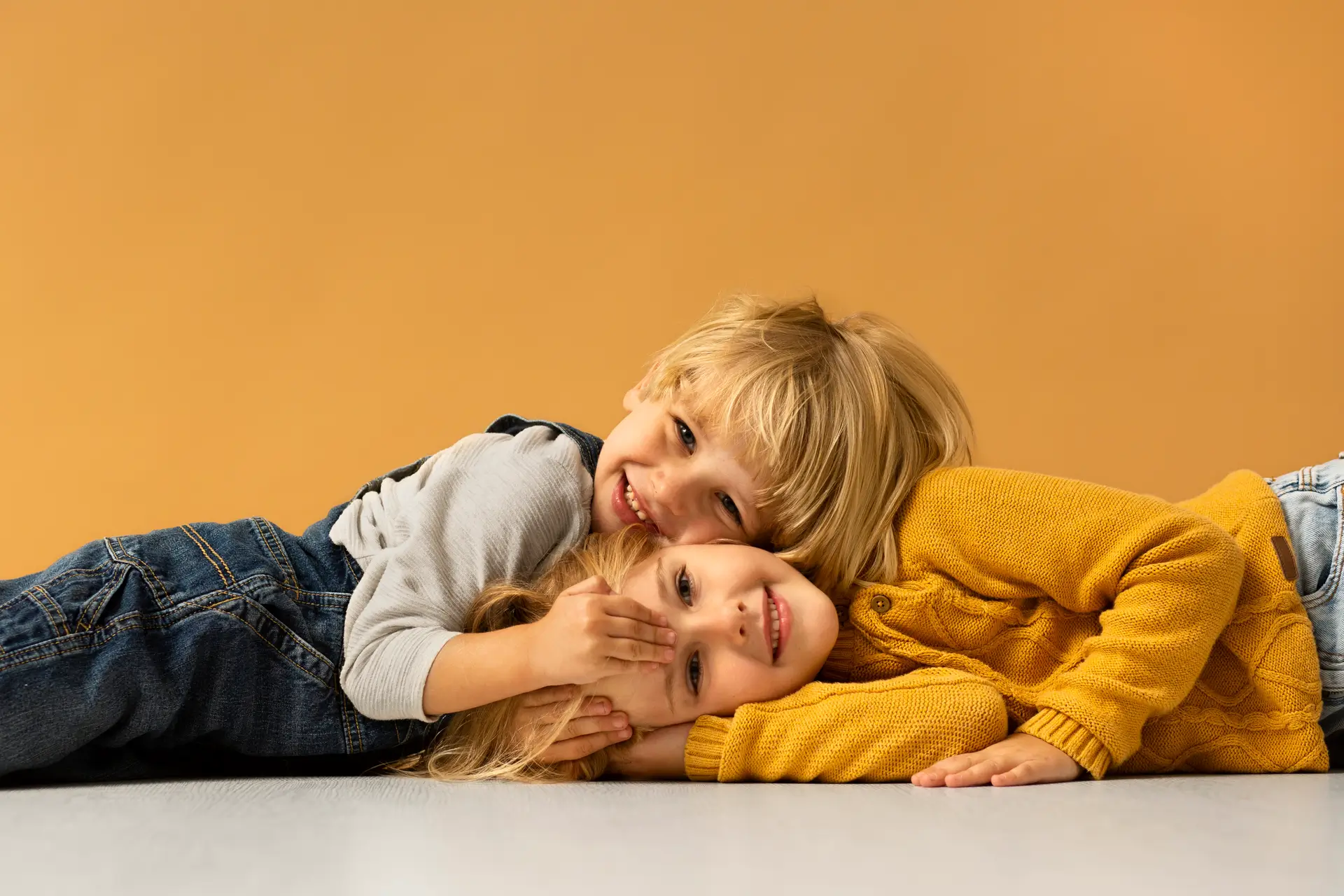 rois enfants souriants, enlacés