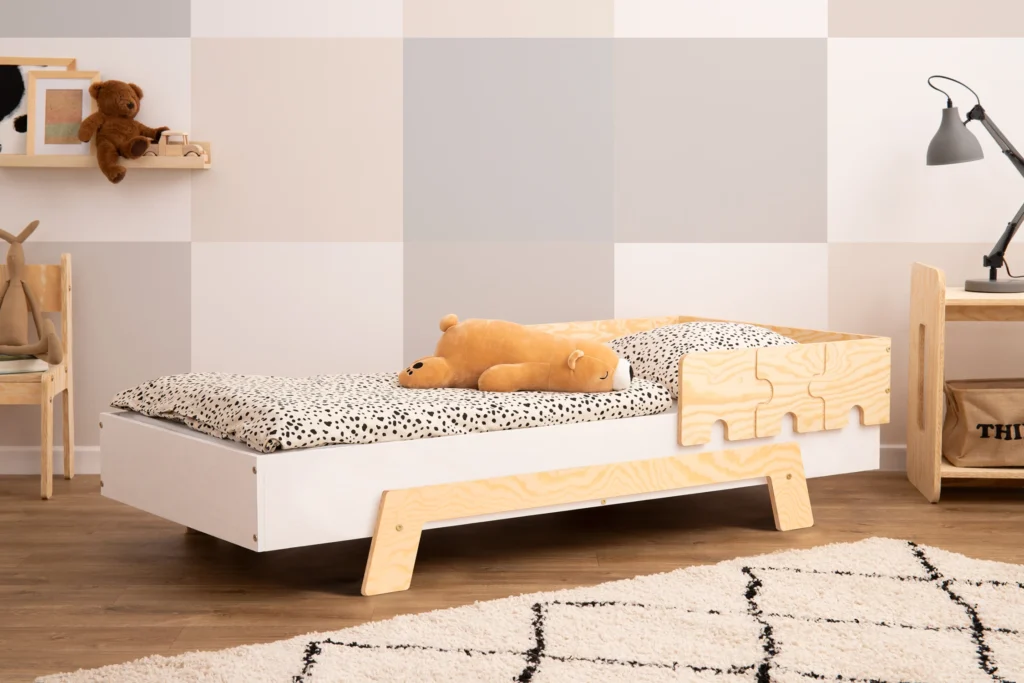 Lit en bois fabriqué en contreplaqué de pin avec une barrière en forme de puzzle en blanc