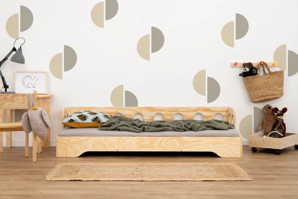 Lit en bois fabriqué en contreplaqué de pin couleur bois naturel avec une barrière à ouvertures rondes