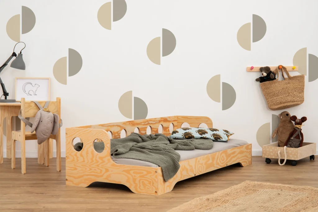 Lit en bois fabriqué en contreplaqué de pin couleur bois verni avec une barrière à ouvertures rondes