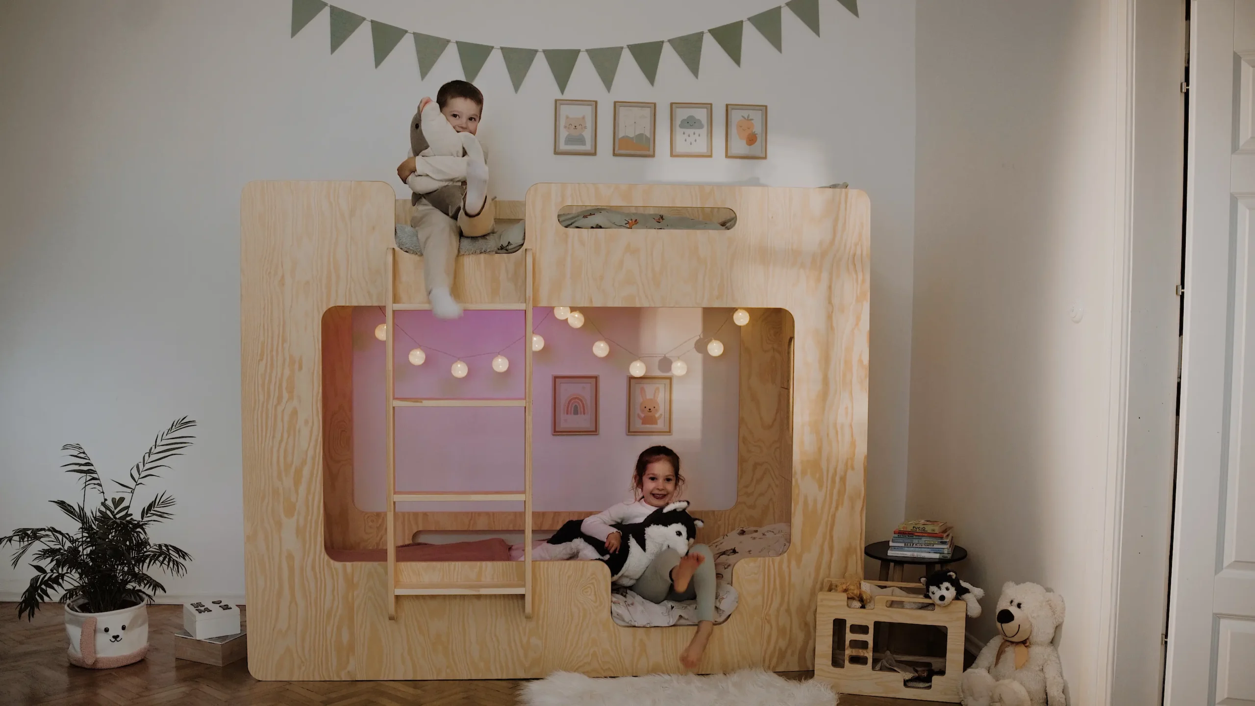 Lit superposé en bois naturel avec structure protectrice — deux enfants en train de jouer